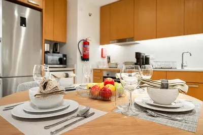 a kitchen with a table with plates and wine glasses at FIRST CLASS 1BR Modern Luxury on High Floor in Dubai