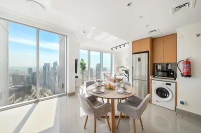 a kitchen with a table and chairs and a large window at FIRST CLASS 1BR Modern Luxury on High Floor in Dubai