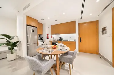 a kitchen and dining room with a table and chairs at FIRST CLASS 1BR Modern Luxury on High Floor in Dubai