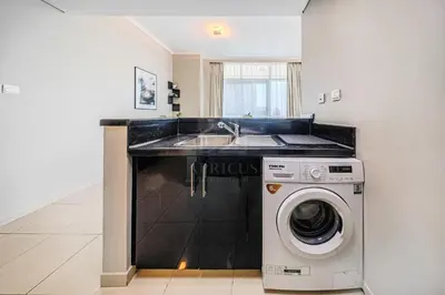 a kitchen with a sink and a washing machine at Elegant 1 Bedroom in Botanica Tower Marina in Dubai