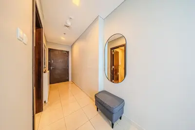 a hallway with a mirror and a blue ottoman at Elegant 1 Bedroom in Botanica Tower Marina in Dubai