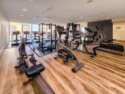 a gym with several treadmills and cardio machines at Elegant 1 Bedroom in Botanica Tower Marina in Dubai