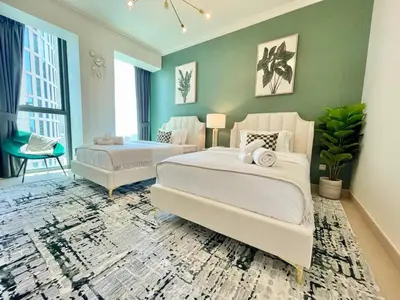 a large bedroom with two beds and a couch at Burj Khalifa & Fountain From Your Balcony Near Dubai Mall & Metro in Dubai