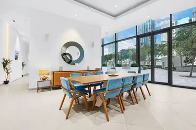 a dining room with a wooden table and blue chairs at Burj Khalifa & Fountain From Your Balcony Near Dubai Mall & Metro in Dubai