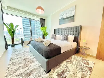a bedroom with a large bed and a large window at Burj Khalifa & Fountain From Your Balcony Near Dubai Mall & Metro in Dubai