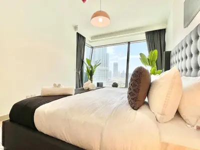 a bedroom with a large bed with a large window at Burj Khalifa & Fountain From Your Balcony Near Dubai Mall & Metro in Dubai