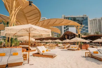 a beach with chairs and umbrellas on the sand at FIVE Palm Jumeirah Premier Apartments in Dubai