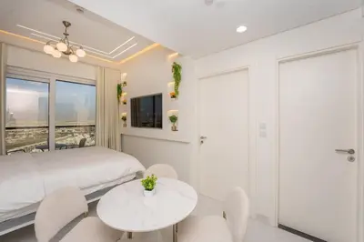 a bedroom with a bed and a table and chairs at Designer 1BR I Golf View I Comfortably Sleeps 4 in Dubai