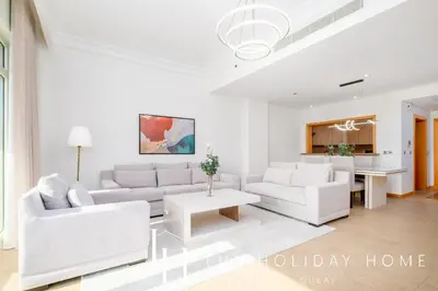 a living room with two white couches and a table at LUX The Palm Island Shoreline Suite in Dubai