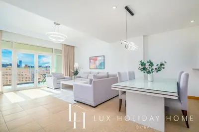 a living room with a dining table and chairs at LUX The Palm Island Shoreline Suite in Dubai