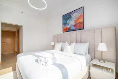 a bedroom with a large white bed and a table at LUX The Palm Island Shoreline Suite in Dubai