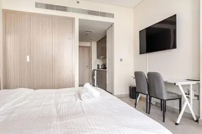 a bedroom with a bed and a desk and a television at Studio Free Parking Pet Friendly Near Downtown Dubai in Dubai