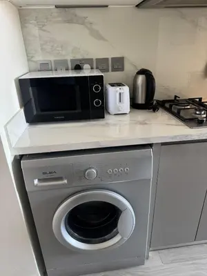 a kitchen with a microwave and a washing machine at Studio Free Parking Pet Friendly Near Downtown Dubai in Dubai
