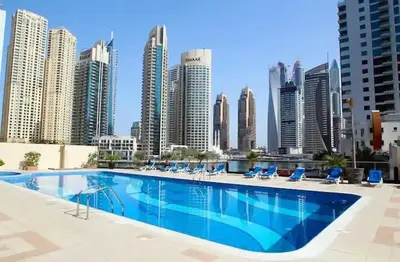 a large swimming pool in front of a city skyline at Lovely Cozy Studio l Steps to JBR in Dubai