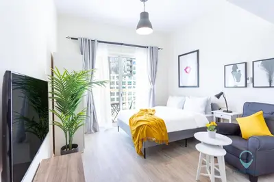 a bedroom with a bed and a couch at Lovely Cozy Studio l Steps to JBR in Dubai