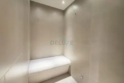 a white bench in a bathroom with a sign on the wall at Pool View Studio with Balcony Close to Mall, Concept 7 Residences, Jumeirah Village Circle by Deluxe Holiday Homes in Dubai