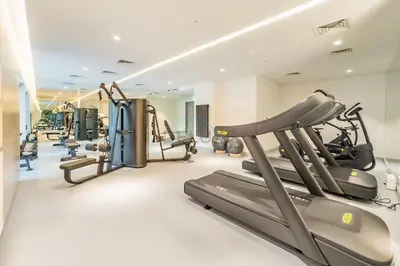 a gym with treadmills and elliptical machines at Pool View Studio with Balcony Close to Mall, Concept 7 Residences, Jumeirah Village Circle by Deluxe Holiday Homes in Dubai