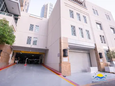 a large white building with a garage at Holidays R Us villa 4 bedroom boulevard view in Dubai