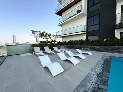 a group of white chairs sitting on top of a building at Modern 1BR Apartment - JVC - WiFi - Pool - Gym in Dubai