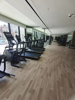 a gym with a row of treadmills and chairs at Stunning 1 Bdr luxury residence at JVC in Dubai