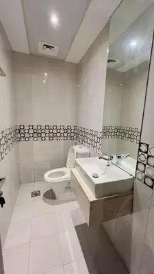 a white bathroom with a toilet and a sink at Amiqa Homes DIP 1 in Dubai