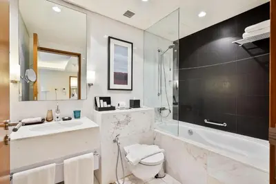 a bathroom with a sink and a toilet and a tub at Luxurious Studio with Burj Khalifa View Direct Dubai Mall Access - Kempinski Residence in Dubai