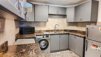 a kitchen with a washing machine and a sink at Sky High 2BR Stay Amazing Marina Views Near Metro & Mall in Dubai