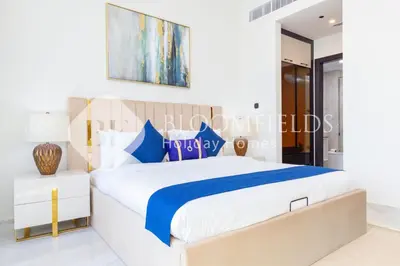 a white bedroom with a blue and white bed at Bloomfields Hidden Gem 1Br with Private Pool in Dubai