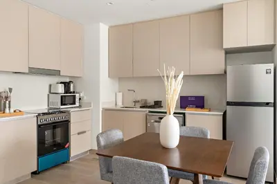 a kitchen with a table with chairs and a vase on it at Silkhaus Chic 1BR in Creek Beach Grove with Pool view in Dubai