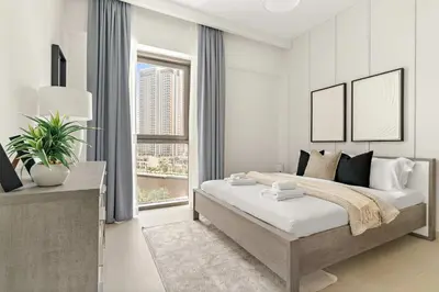 a bedroom with a large bed and a large window at Silkhaus Chic 1BR in Creek Beach Grove with Pool view in Dubai