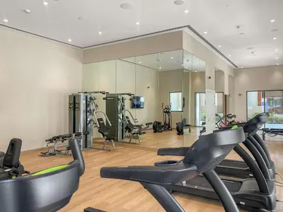 a gym with treadmills and elliptical machines at Silkhaus Chic 1BR in Creek Beach Grove with Pool view in Dubai