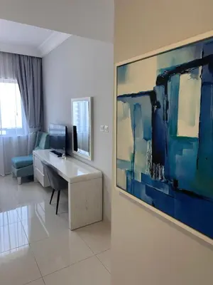 a living room with a desk and a painting on the wall at Cozy 1BR, 2Min to Dubai Mall in Dubai