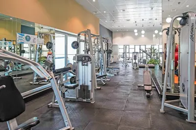 a gym with rows of treadmills and machines at 49 -Elegant Princess Tower Family Apartment with Palm View, Balcony & Pool in Dubai
