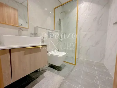 a bathroom with a toilet and a sink and a shower at Comfy 1-Bedroom Apartment at Blue Wave - Liwan in Dubai
