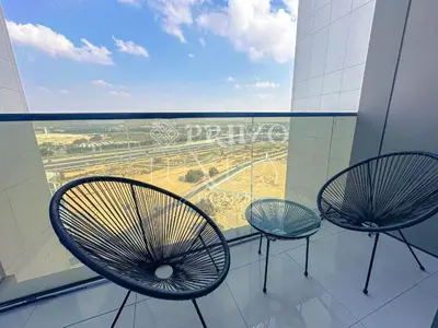 two chairs in front of a window in a building at Comfy 1-Bedroom Apartment at Blue Wave - Liwan in Dubai