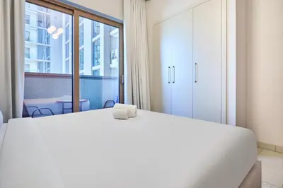 a white bed in a room with a large window at STAY BY LATINEM Luxury 1BR Holiday Home CVR A901 near Downtown in Dubai