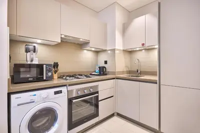 a kitchen with a washing machine and a microwave at STAY BY LATINEM Luxury 1BR Holiday Home CVR A901 near Downtown in Dubai