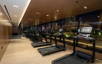 a row of treadmills in a fitness room at Elegant 2br Jvc Private Pool, Balcony & Parking in Dubai