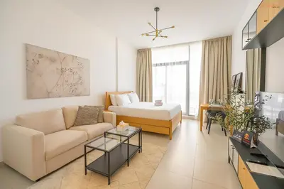 a living room with a couch and a bed at Bnbeyond's Sassy Studio with Expansive Balcony in Dubai