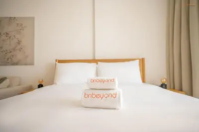 a white bed with two towels on top of it at Bnbeyond's Sassy Studio with Expansive Balcony in Dubai