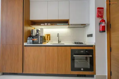 a kitchen with a sink and a stove at Bnbeyond's Sassy Studio with Expansive Balcony in Dubai