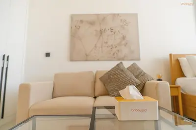 a living room with a couch and a box on a glass table at Bnbeyond's Sassy Studio with Expansive Balcony in Dubai
