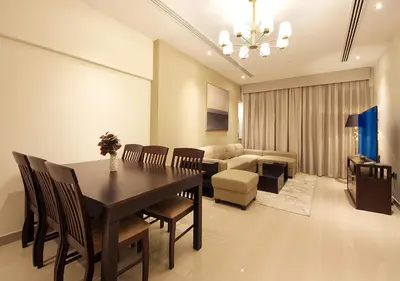 a dining room with a table and chairs and a couch at Stylish 2BR Downtown Apartment Burj & Mall Nearby in Dubai