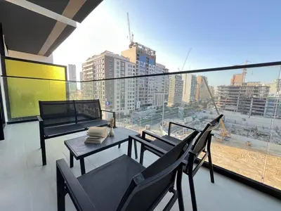 a balcony with a table and chairs and a view of a city at Peaceful 1br Jvc Pool, Balcony, Parking in Dubai