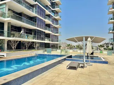 a swimming pool in front of a large building at FIRST CLASS Studio Urban Hideaway in Dubai