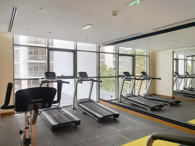 a gym with several tread machines in a room with windows at FIRST CLASS Studio Urban Hideaway in Dubai
