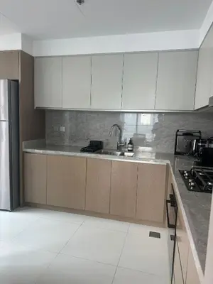 a kitchen with white cabinets and a sink at Palm & Marina View 1BR Apartment at Emaar Beachfront in Dubai