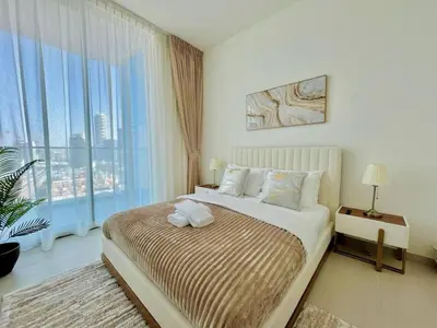 a bedroom with a bed and a large window at Luxury 2br Private Pool & Balcony Jvc in Dubai