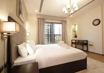 a bedroom with a large white bed and a window at Elegant 2BR with City Views Downtown Dubai Living in Dubai