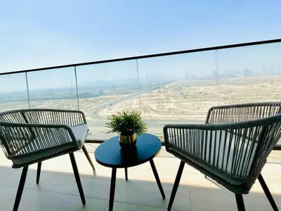 two chairs and a table on a balcony with a view at Jvc 1br Apartment Modern Comfort, Pool, Parking in Dubai